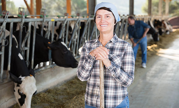 Freundlich lächelnde Landwirtin im Kuhstall